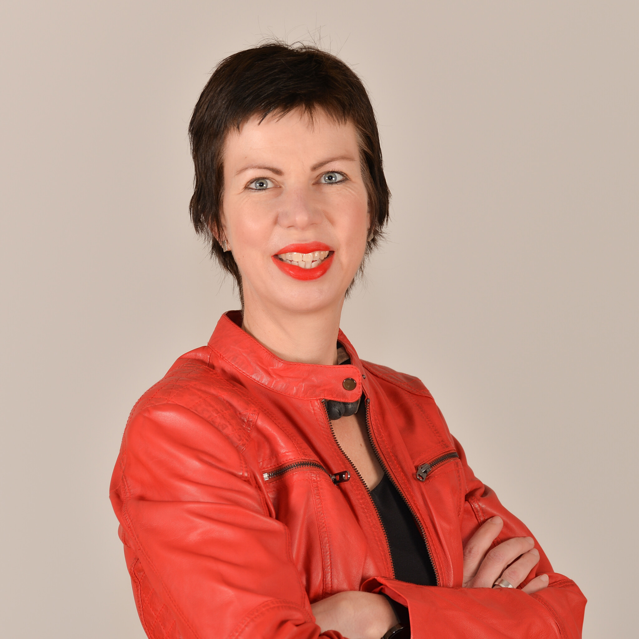 Profilbild von Dr. Martina Diedrich. Sie trägt eine schwarze Bluse und eine rote Lederjacke.